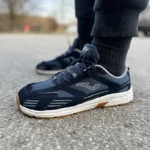 Dark blue barefoot sneakers with white sole worn outdoors