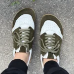Green barefoot sneakers worn outdoors, top view